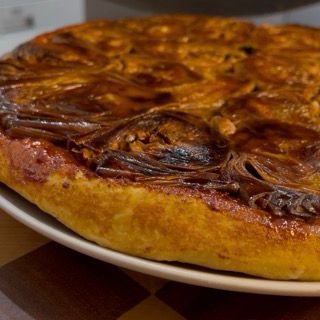La tarte tatin rovesciata sul piatto, fumante e con i carciofi caramellati