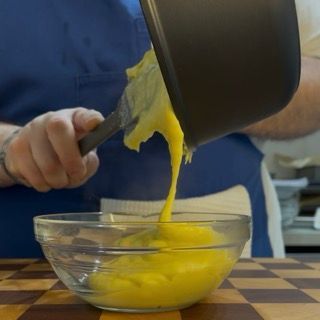 Crema al parmigiano che raffredda coperta con pellicola a contatto