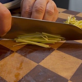 Coltello che taglia i gambi di carciofo crudi a fettine sottilissime