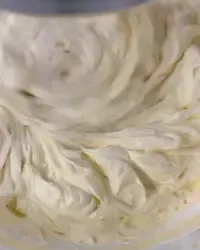 Crema al mascarpone densa e omogenea per tiramisù lavorata con una spatola in una ciotola.