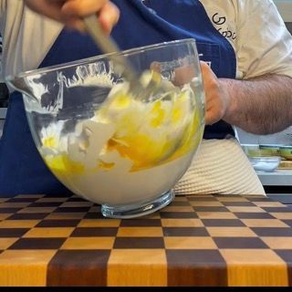 Composto soffice di uova e miele mescolato delicatamente per la torta tiramisù compleanno.