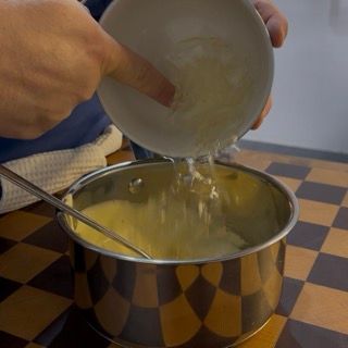 Scioglimento della gelatina nel composto caldo per la stabilità della torta tiramisù facile.