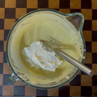 Integrazione della panna montata ben ferma nella crema al mascarpone per la torta tiramisù.