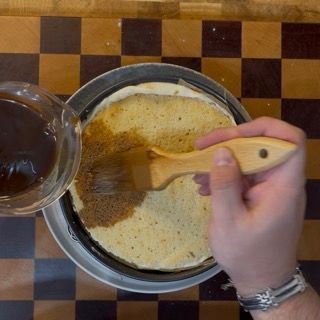 Leggera pressione manuale del disco di savoiardo seguita da un'abbondante inzuppa al caffè.