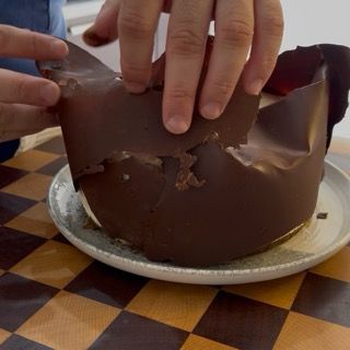 Decorazione moderna con teli di cioccolato sovrapposti sulla superficie della torta tiramisù.