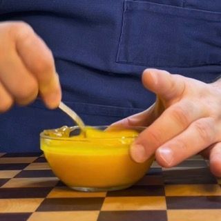 Amalgama di tuorli d'uovo con miele in ciotola prima dell'unione con gli albumi montati.