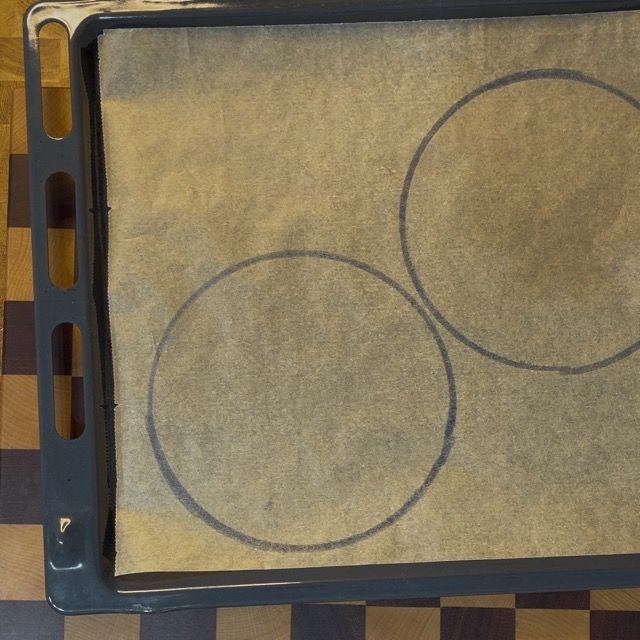 Formazione dei dischi di pasta savoiardo a spirale sulla teglia prima della cottura in forno.