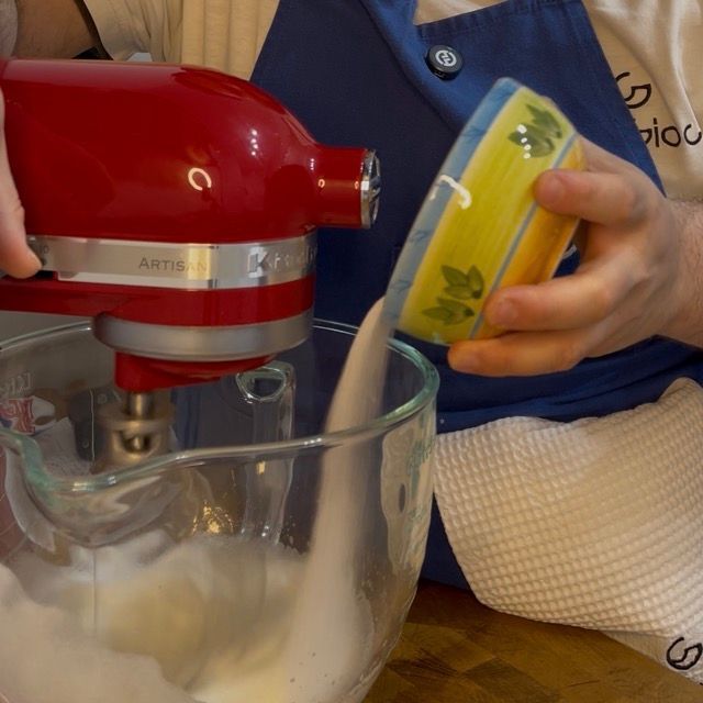 Zucchero aggiunto a pioggia mentre le fruste montano.