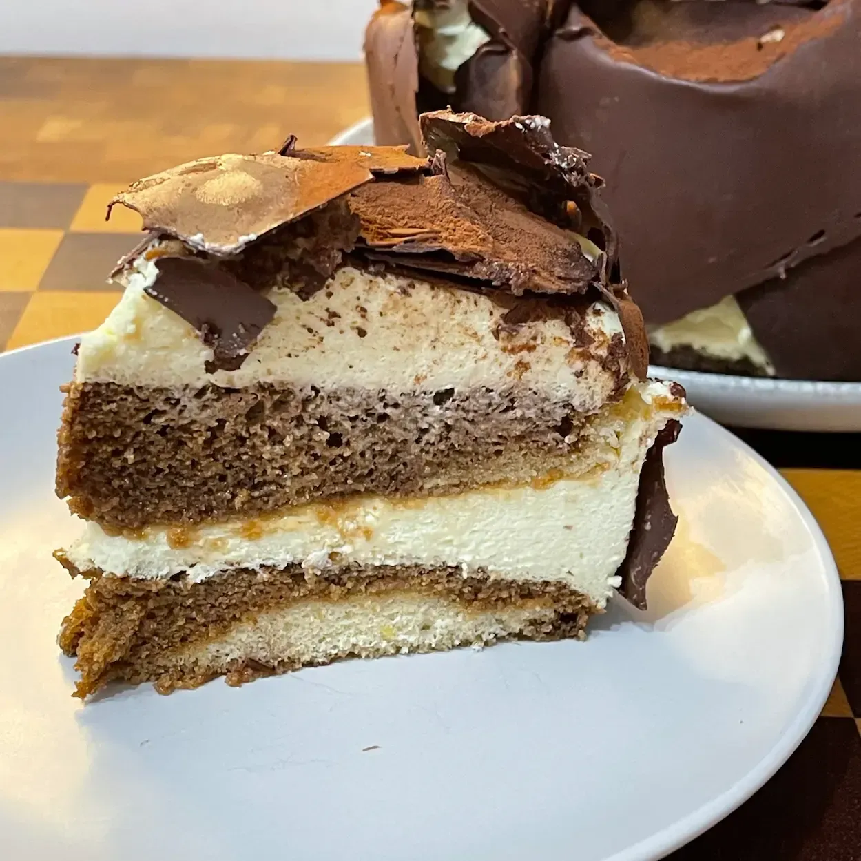 Dettaglio della fetta di torta tiramisù facile e cremosa senza uova crude, con strati di savoiardi al caffè.