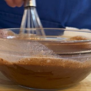 Versamento della ganache negli stampini a semisfera per il cuore del fondant al cioccolato.