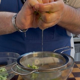 Strizzatura energica del cetriolo grattugiato per eliminare ogni residuo d'acqua dalla tzatziki salsa.
