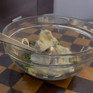 Aggiunta di aglio grattugiato e sale al composto, omettibile se si desidera preparare un tzatziki senza aglio.