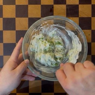 Mescolamento accurato di tutti gli ingredienti per amalgamare i sapori della tzatziki ricetta originale greca.