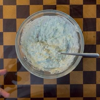 Ciotola di tzatziki fresco guarnito con un filo d'olio evo ed erbe, perfetta crema greca povera di calorie.