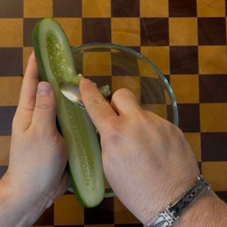 Rimozione dei semi centrali del cetriolo con un cucchiaio per ottenere una tzatziki ricetta originale greca.