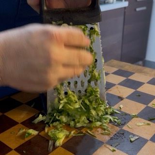 Dettaglio del cetriolo grattugiato finemente con la sua buccia per la vera salsa greca yogurt e cetrioli.