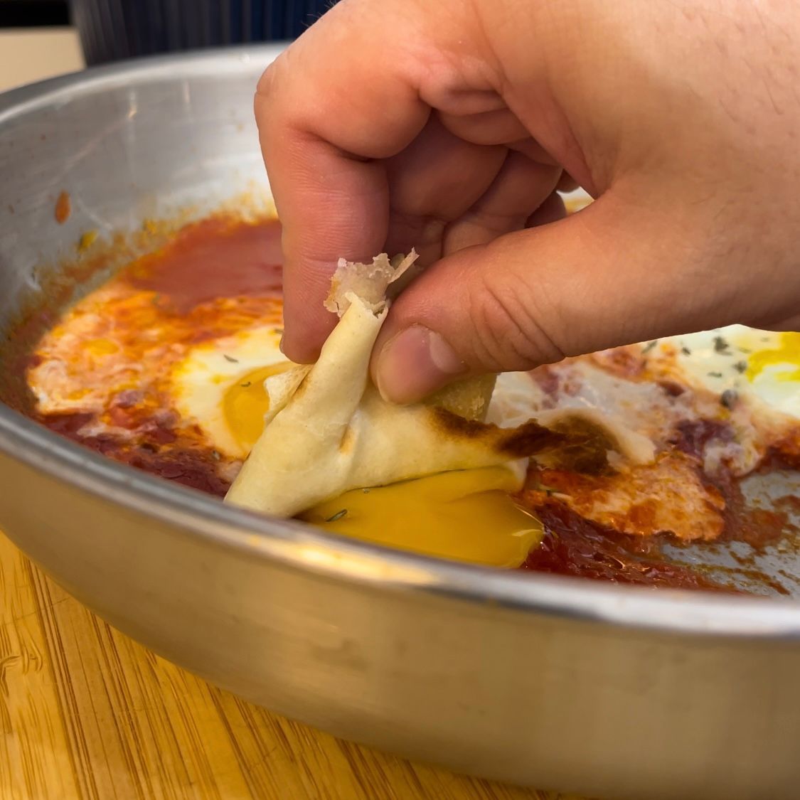 Una persona sta prendendo un pezzo di cibo da una padella