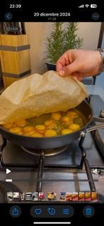 Una persona sta cucinando del cibo in una padella sul fornello.