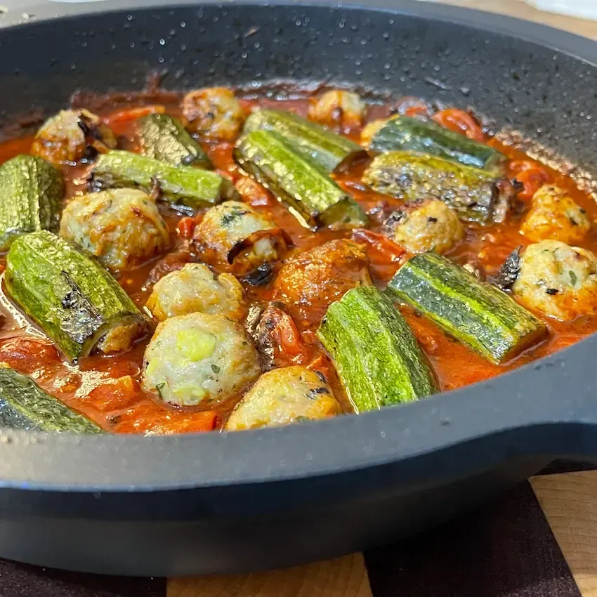 Teglia di zucchine ripiene alla romana al forno appena sfornate, con un ripieno di carne e mortadella morbido e dorato.