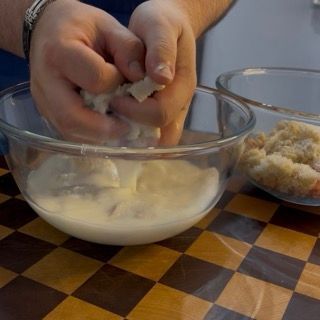 Strizzatura energica del pane bagnato nel latte per eliminare il liquido in eccesso dal ripieno delle zucchine.