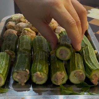 Vassoio con le zucchine ripiene alla romana e le golose polpettine di contorno pronte per il tegame.