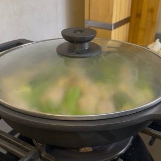 Sfumatura con vino bianco a fiamma alta per far evaporare l'alcol e insaporire le zucchine ripiene in tegame.