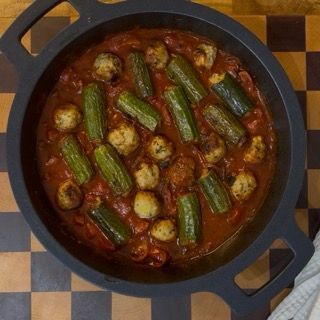 Impiattamento delle zucchine ripiene di carne con abbondante salsa cremosa, pronte da gustare subito.