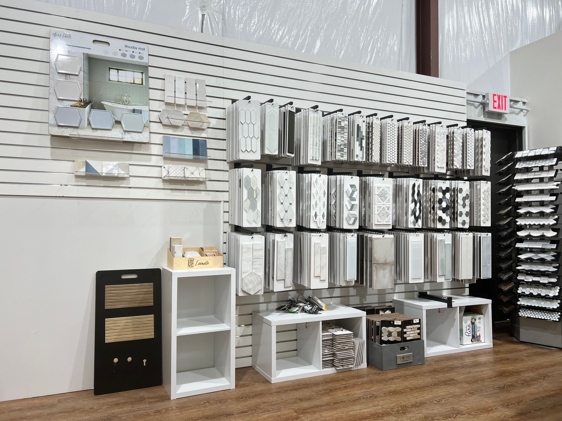 Wall display of packaged items in a store aisle with shelves and bins beneath the products