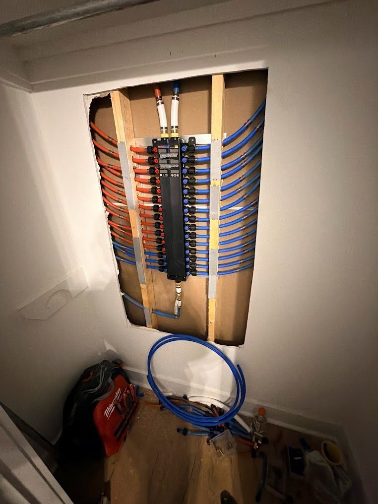Open electrical panel with rows of red and blue wiring and a blue cable loop below