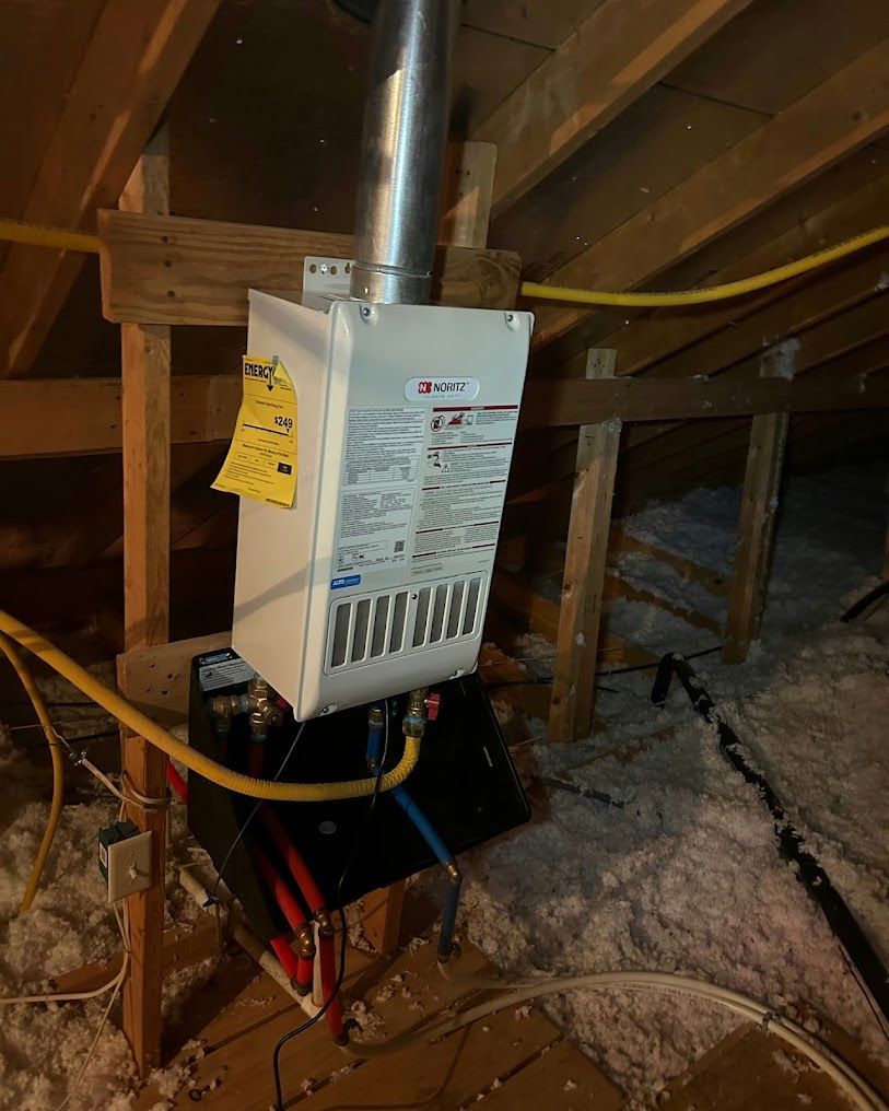 Electrical breaker panel mounted in an unfinished attic with exposed wood framing and wiring