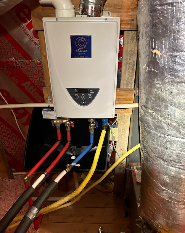 Wall-mounted water heater with red, blue, and yellow pipes in a utility closet