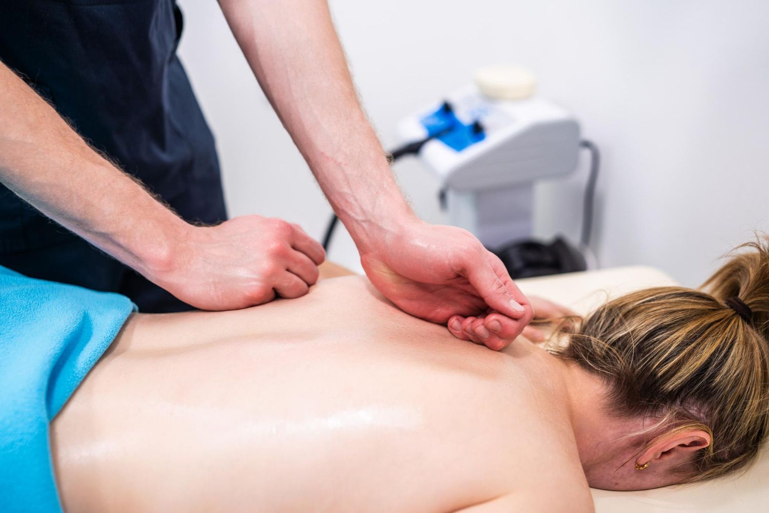 A woman is laying on a bed getting a massage from a man.