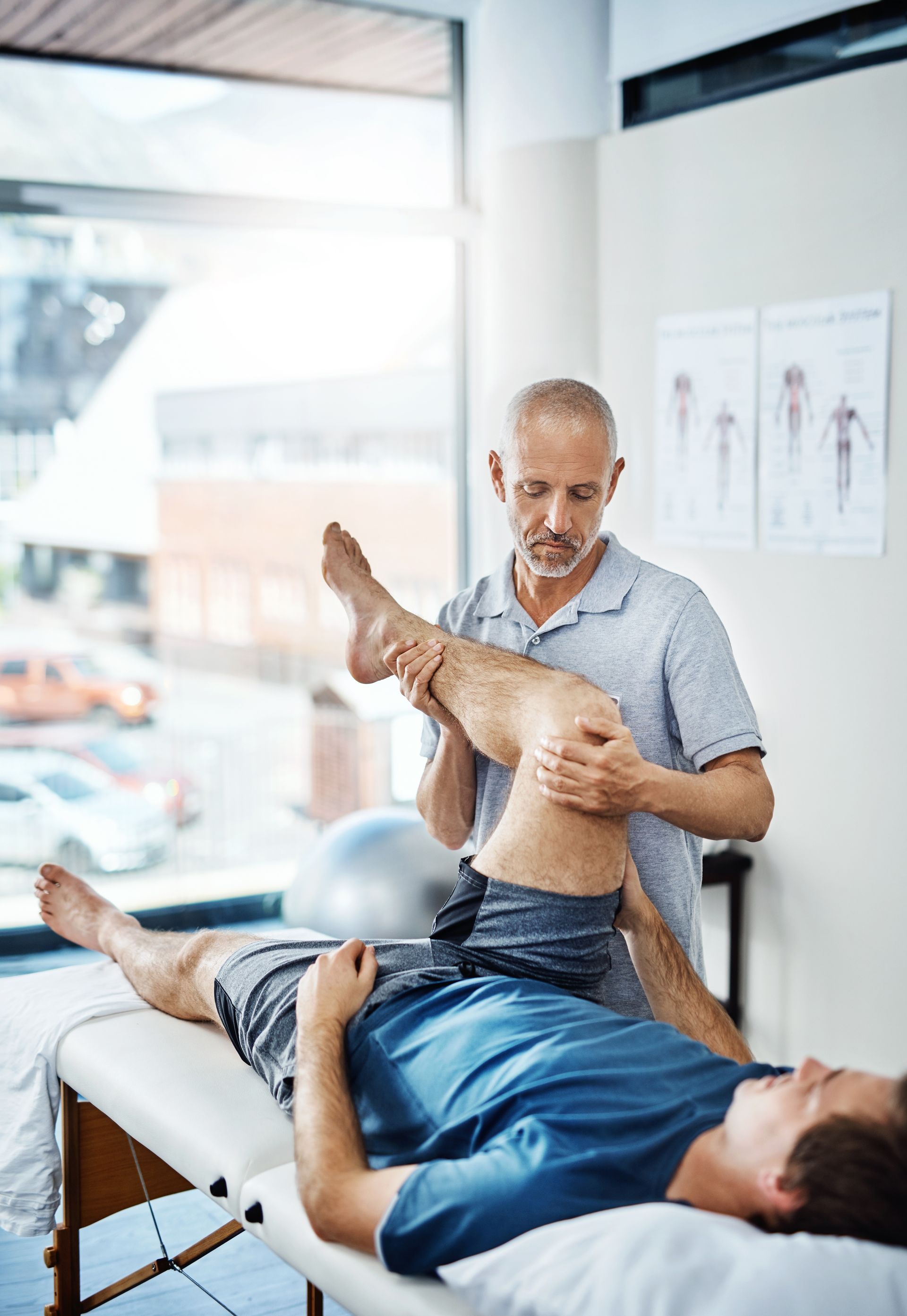 A man is laying on a table getting his leg examined by a doctor in Guelph, ON