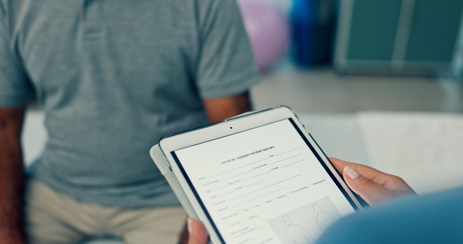 A person is holding a tablet in front of a man in Guelph, ON.