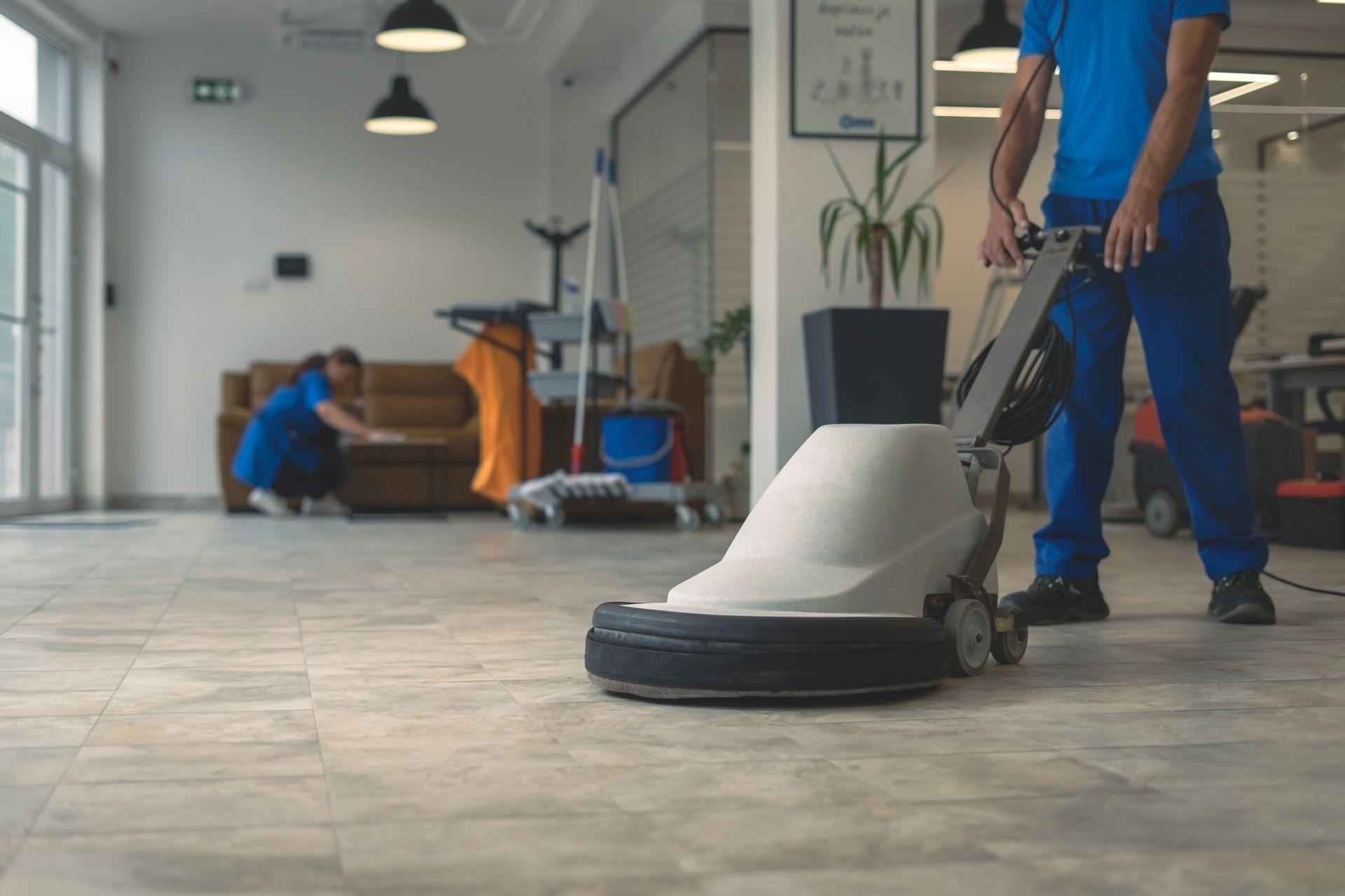 Cleaning the floor with a machine in an office.