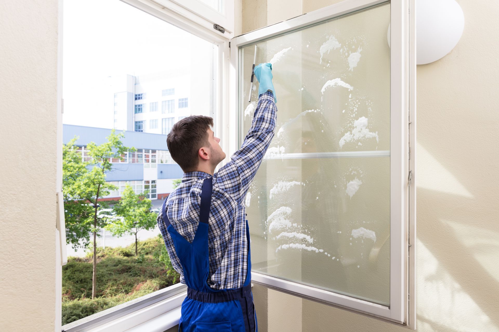 Cleaning a window in a room.