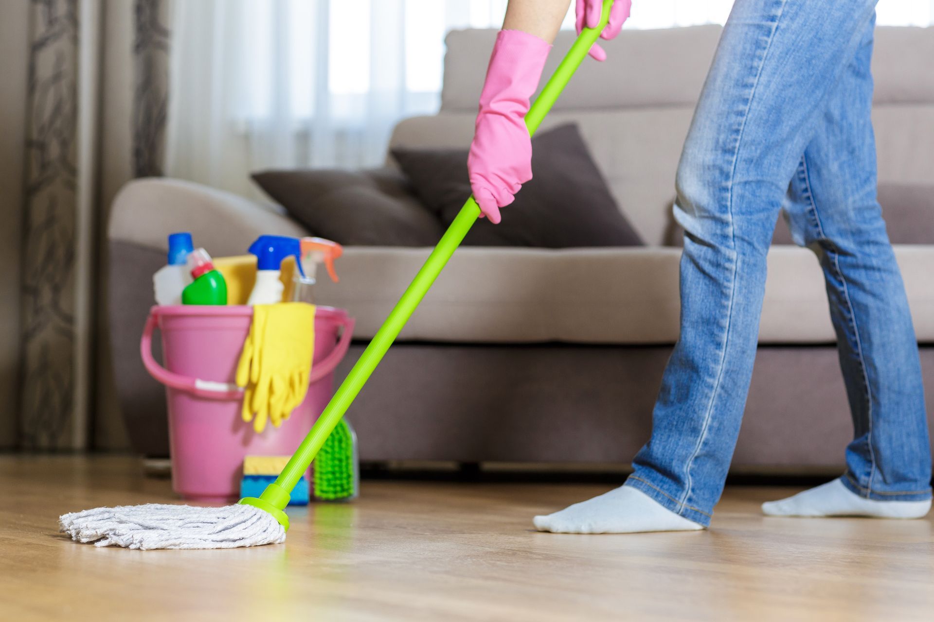 Cleaning the floor with a mop in a living room.
