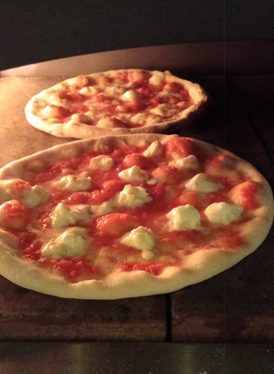 Due pizze crude con salsa di pomodoro e formaggio in forno