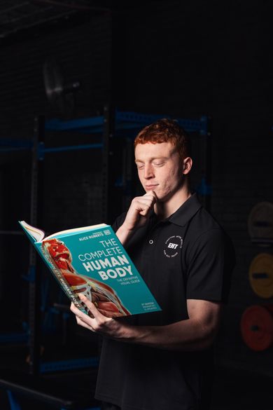 Person reading a teal book titled 