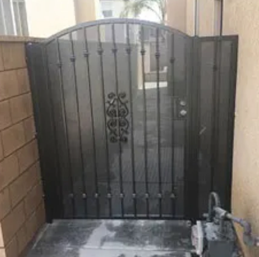 Black metal security gate at the end of a narrow outdoor passage between walls