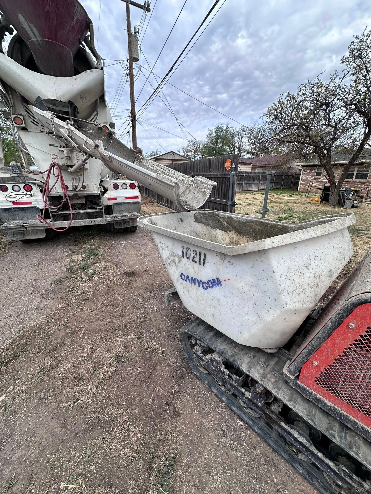 Damaged construction equipment after a crash, with a red truck and debris in a muddy yard