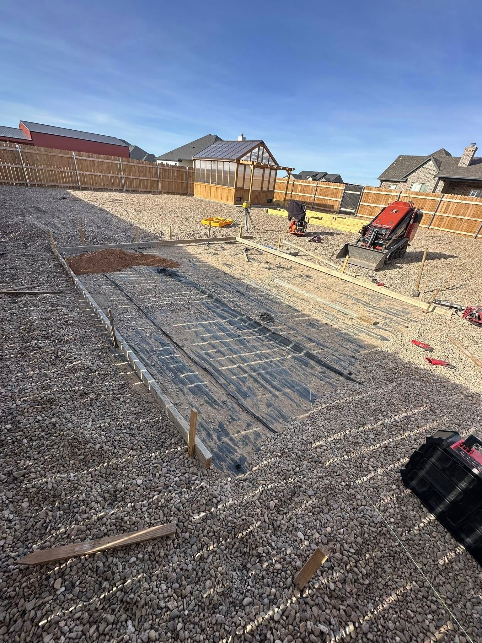 Roof under construction with workers, gravel, and houses in the background