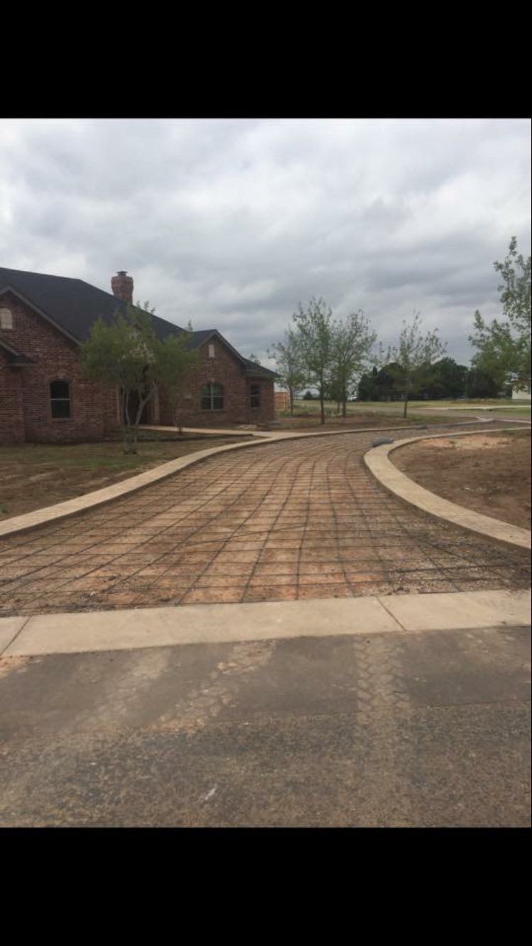 Curved brick walkway beside a brick building under a cloudy sky