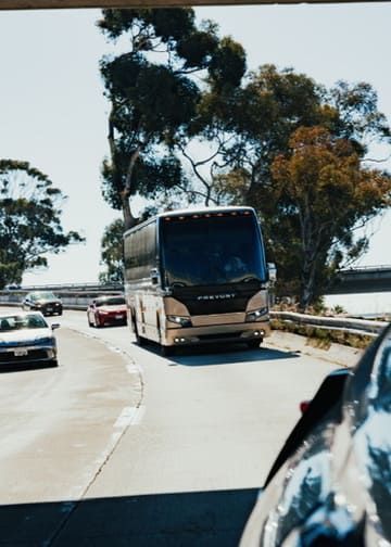 charter bus driving on highway for group transportation service in San Diego