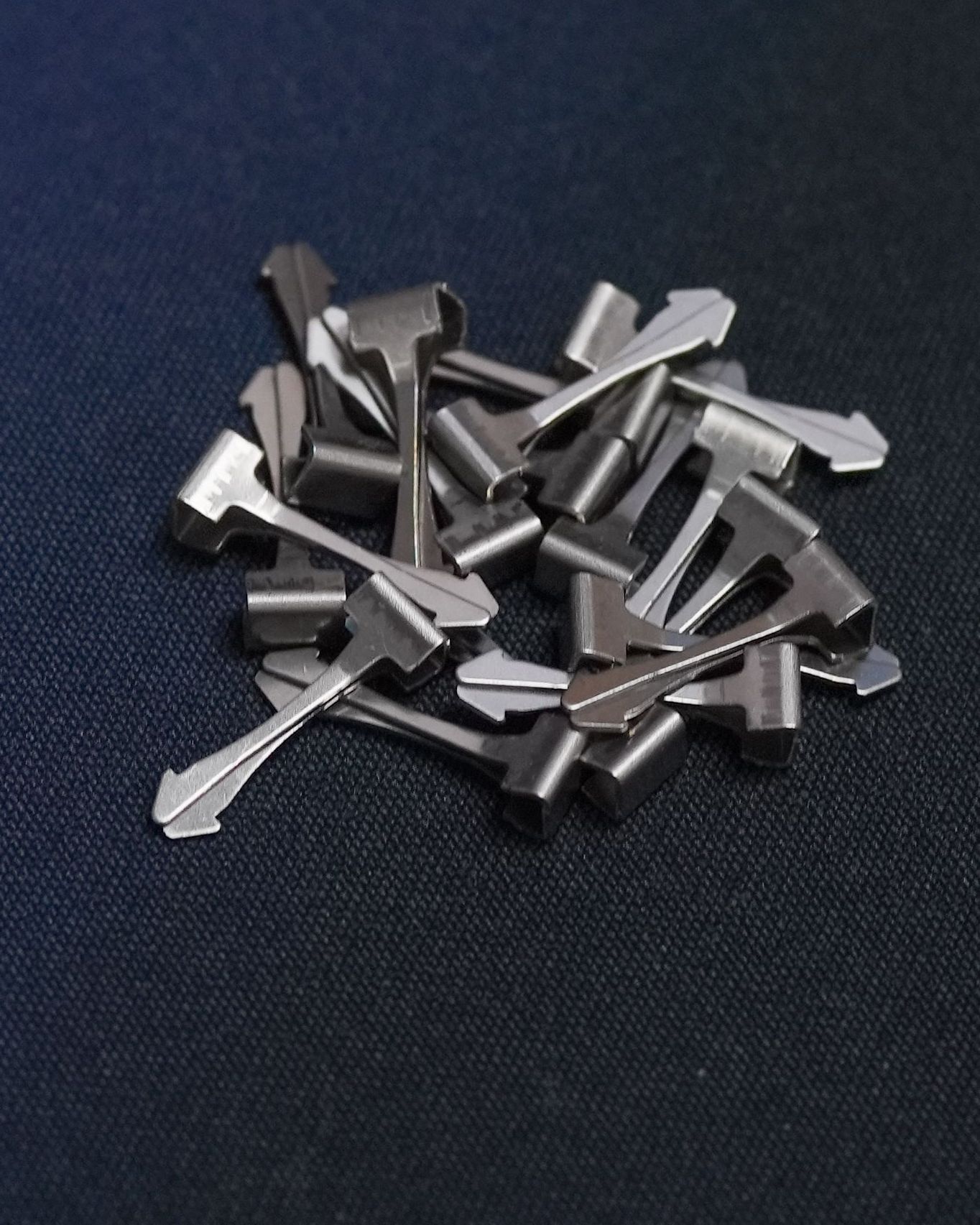 A pile of metal keys on a blue surface
