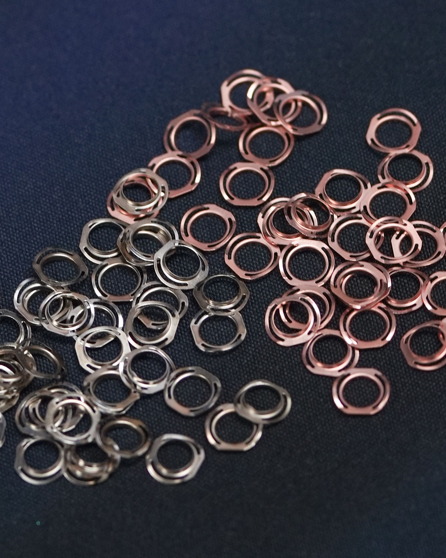 A pile of copper and silver rings on a black surface