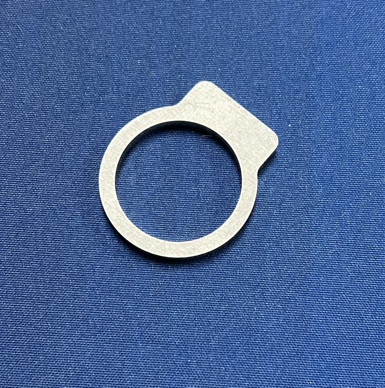 A silver ring is sitting on a blue cloth