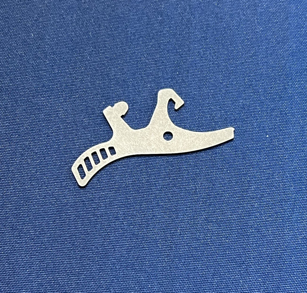 A small piece of metal is sitting on top of a blue cloth.