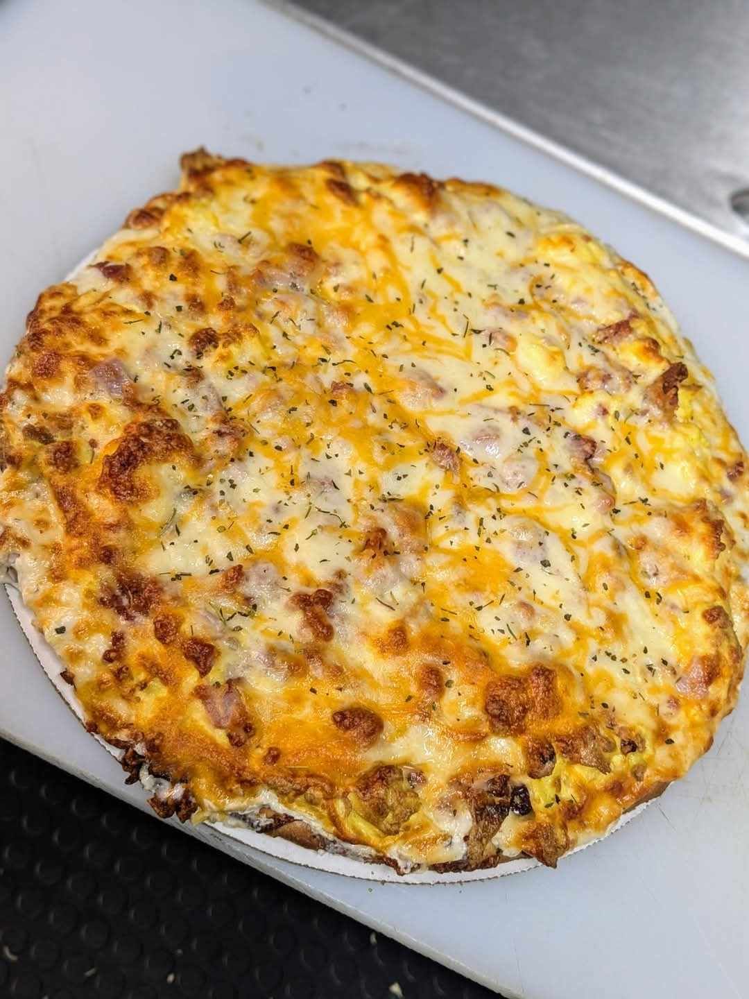 A pizza is sitting on a cutting board on a table.