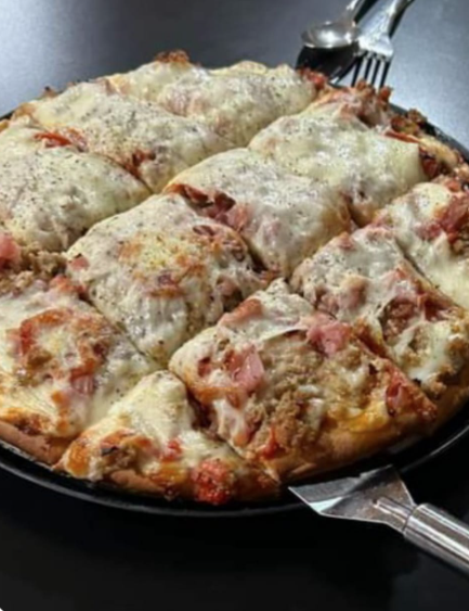 Meat lovers pizza being served on a tray.